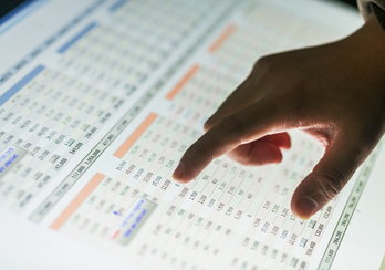 Person points at numbers on a chart